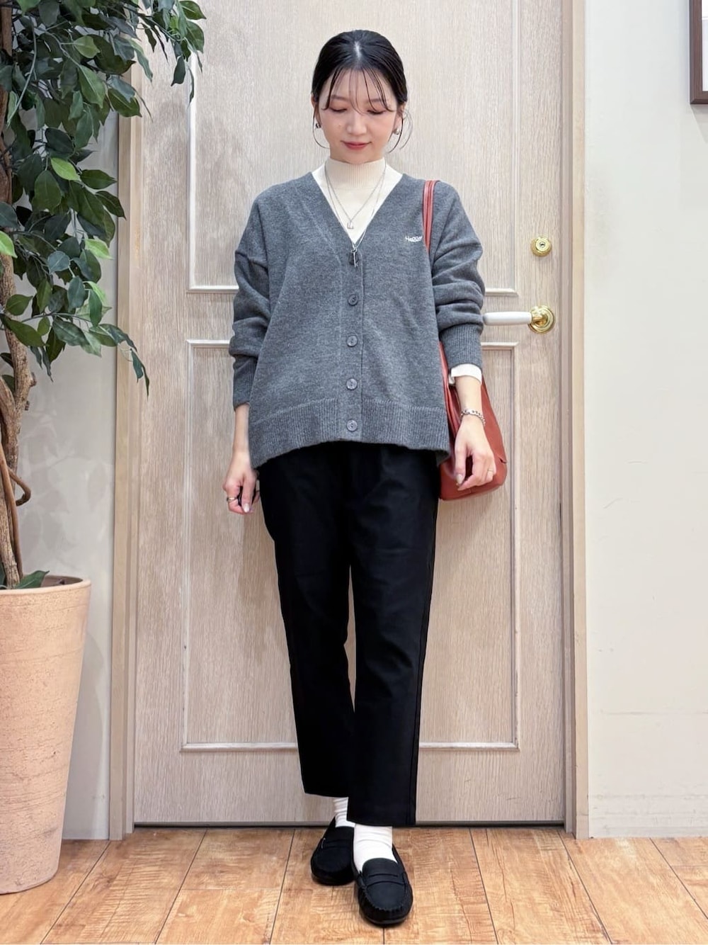 グレー系のカーディガン/ボレロ、ホワイト系のニット/セーター、ブラック系のその他パンツを着用したレディースの冬コーディネートの1枚目の写真