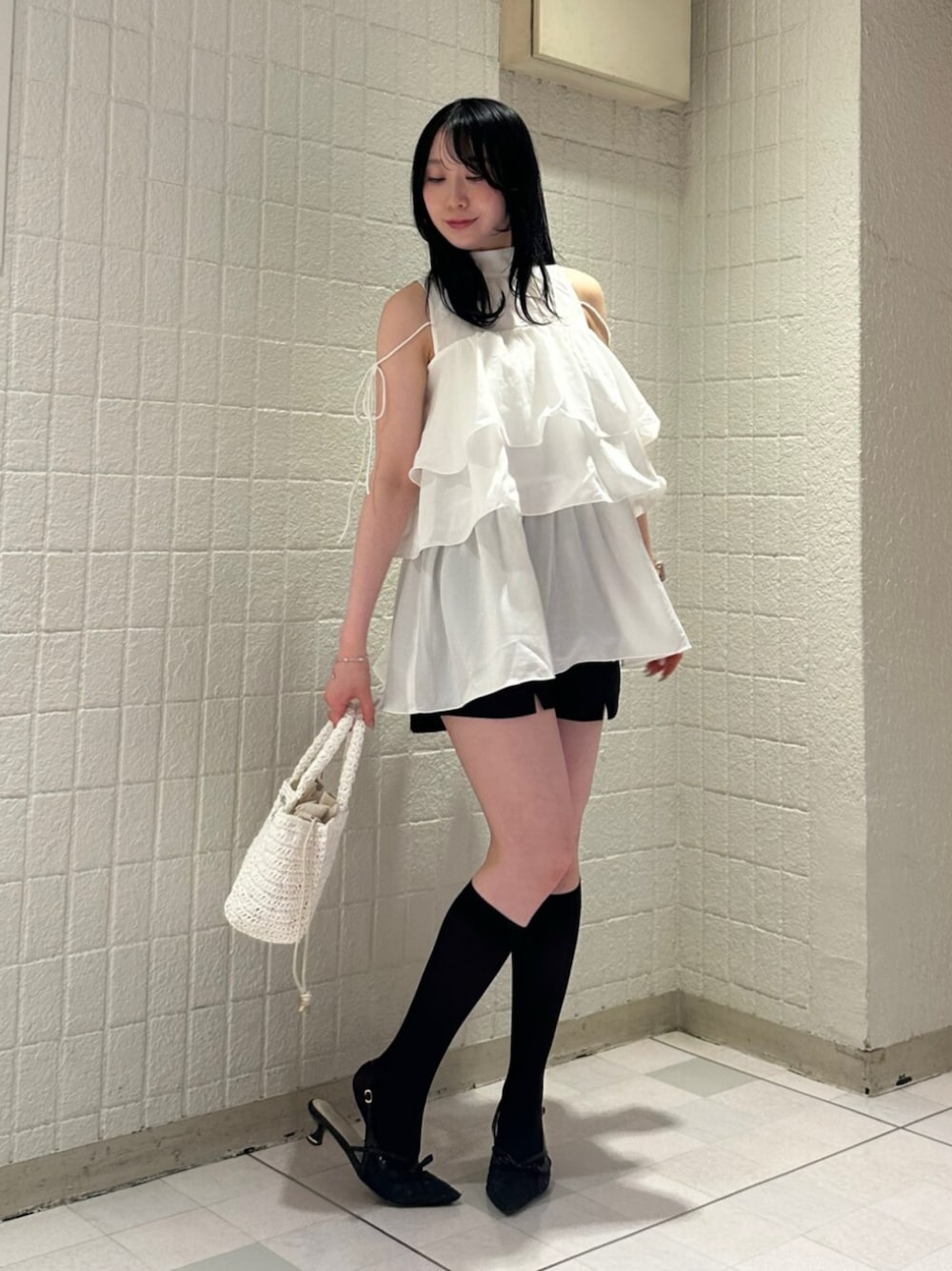 ホワイト系のシャツ/ブラウス、ブラック系のパンプス、ホワイト系のかごバッグを着用したレディースの夏コーディネートの1枚目の写真