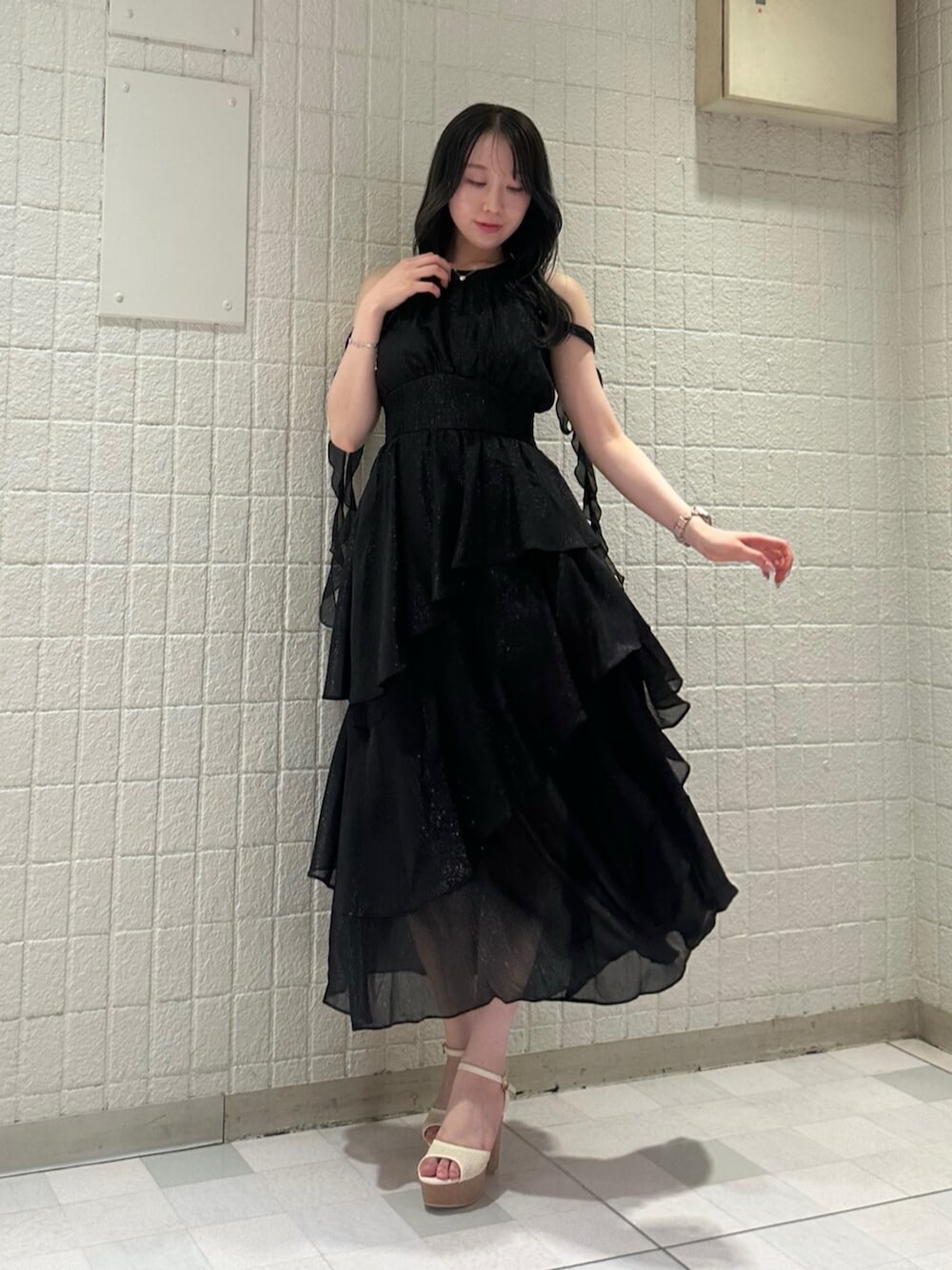 ブラック系のワンピース、ホワイト系のサンダルを着用したレディースの夏コーディネートの1枚目の写真