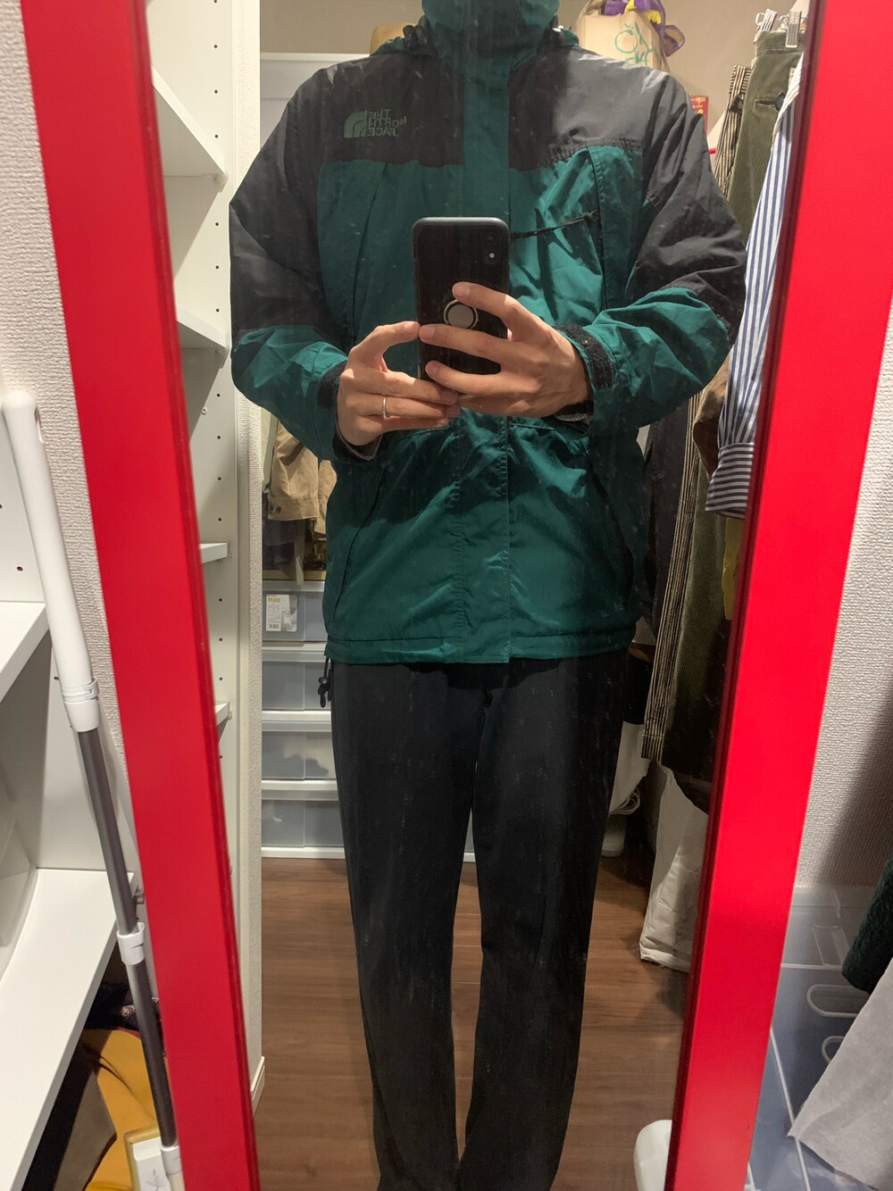 ブラック系のチノパンツ、グリーン系のマウンテンパーカーを着用したメンズの冬コーディネートの1枚目の写真