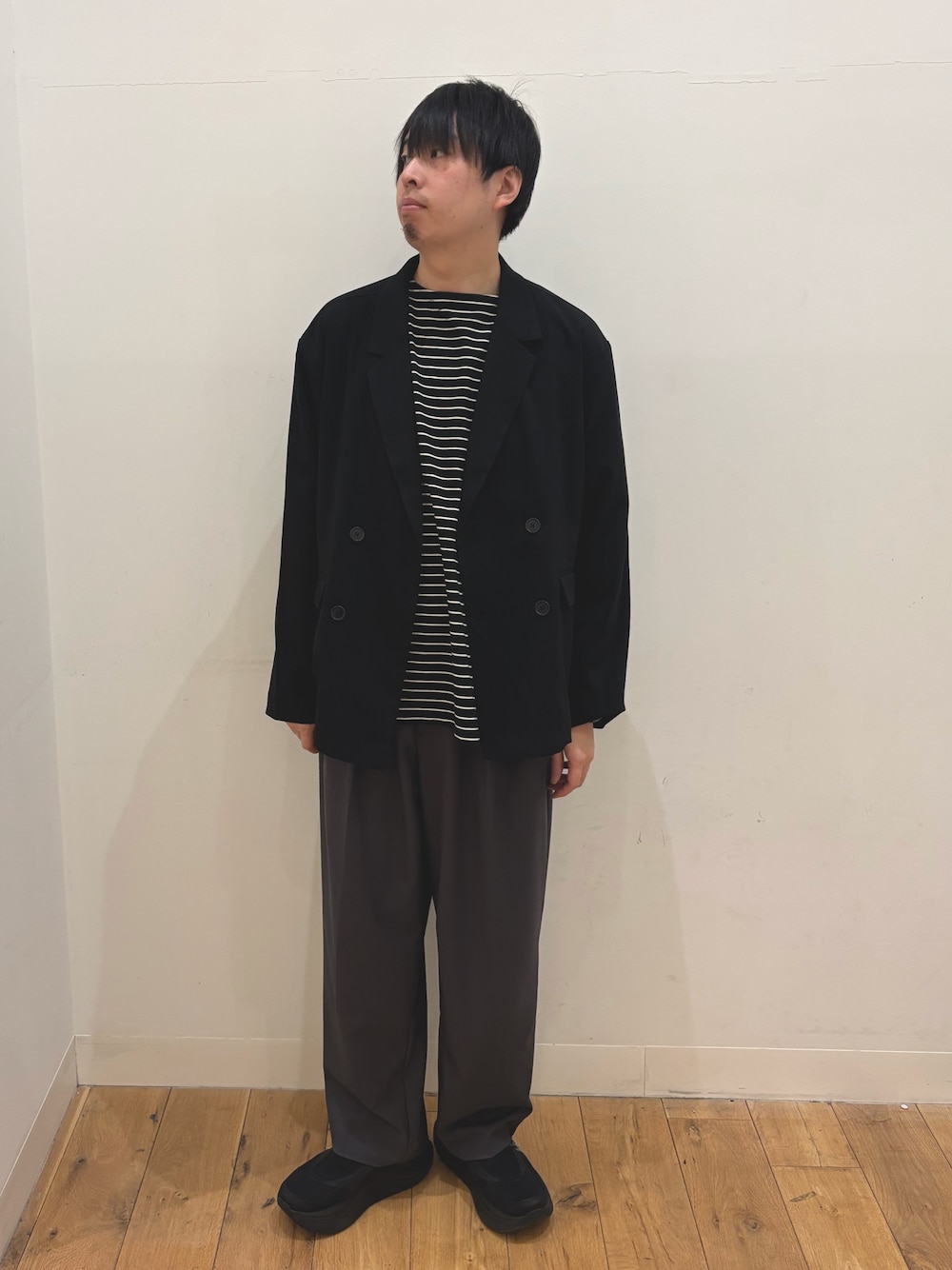 ブラック系のテーラードジャケット、ブラック系のTシャツ/カットソー、グレー系のその他パンツを着用したメンズの春コーディネートの1枚目の写真