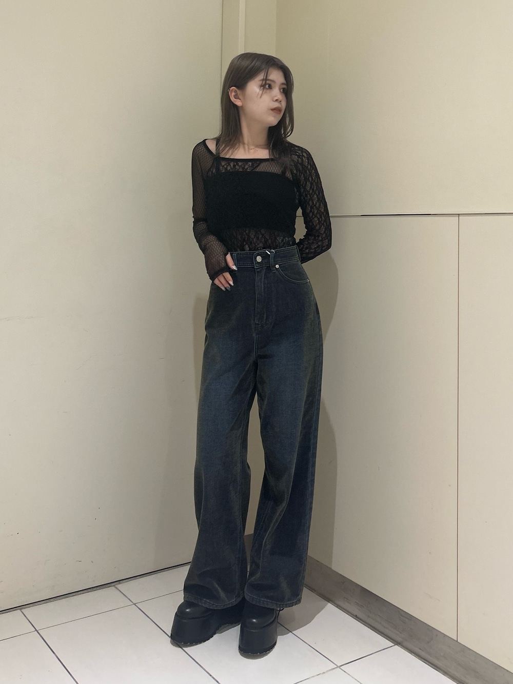 グリーン系のデニムパンツ、ブラック系のTシャツ/カットソー、ブラック系のブーツを着用したレディースの秋コーディネートの1枚目の写真