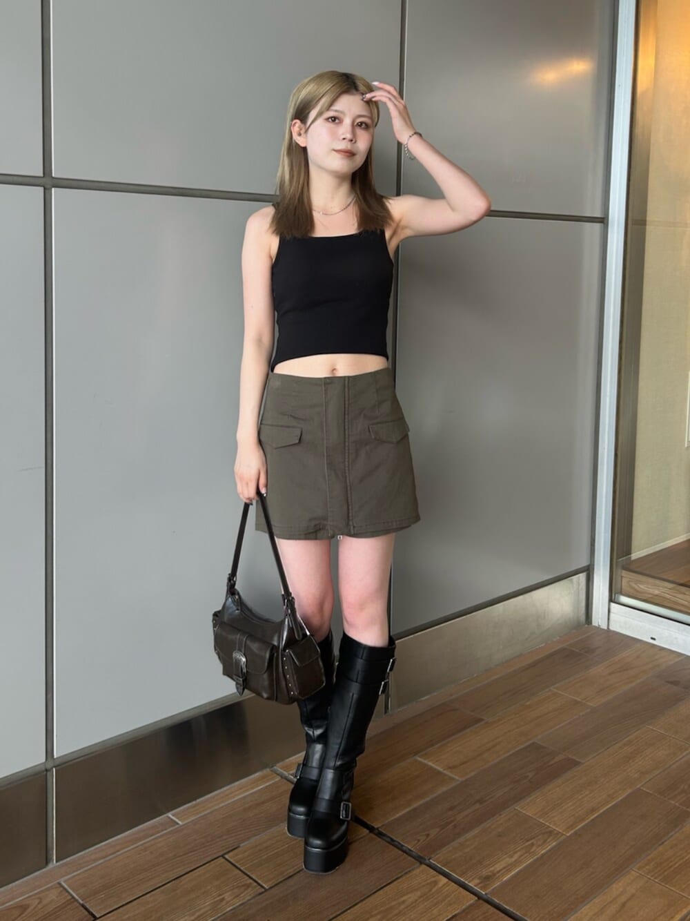 ブラック系のタンクトップ、グリーン系のその他パンツ、ブラック系のブーツを着用したレディースの夏コーディネートの1枚目の写真