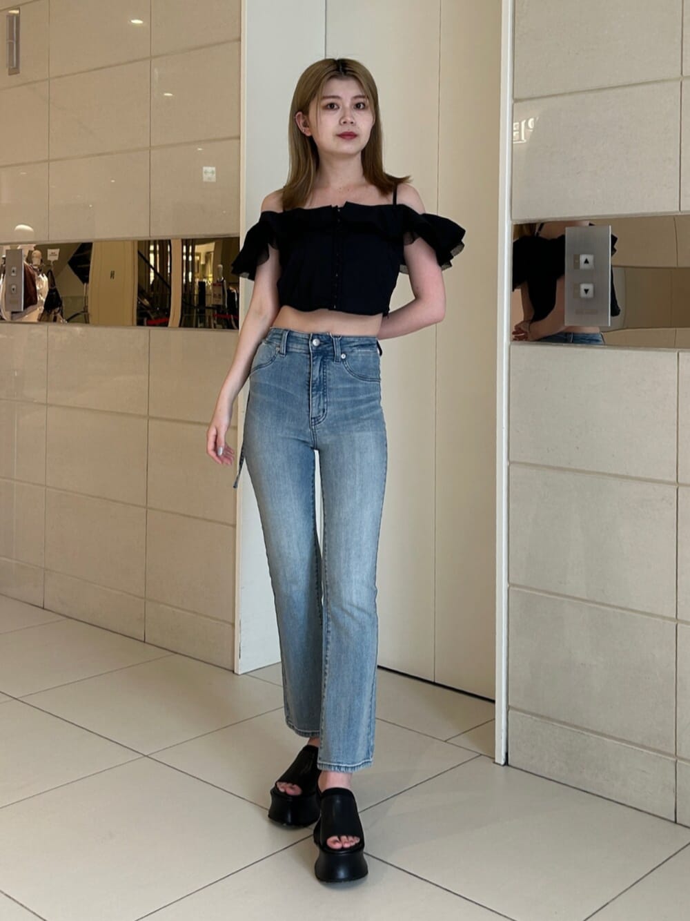 ブルー系のデニムパンツ、ブラック系のシャツ/ブラウス、ブラック系のサンダルを着用したレディースの夏コーディネートの1枚目の写真
