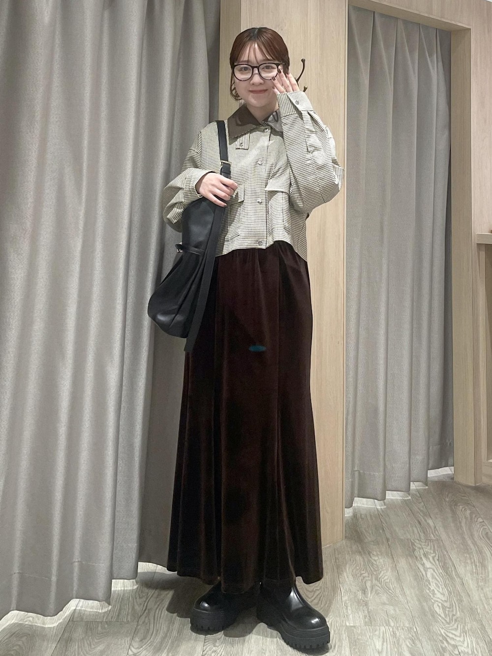 ブラック系のショルダーバッグ、ブラック系のブーツ、ベージュ系のカバーオールを着用したレディースの秋コーディネートの1枚目の写真