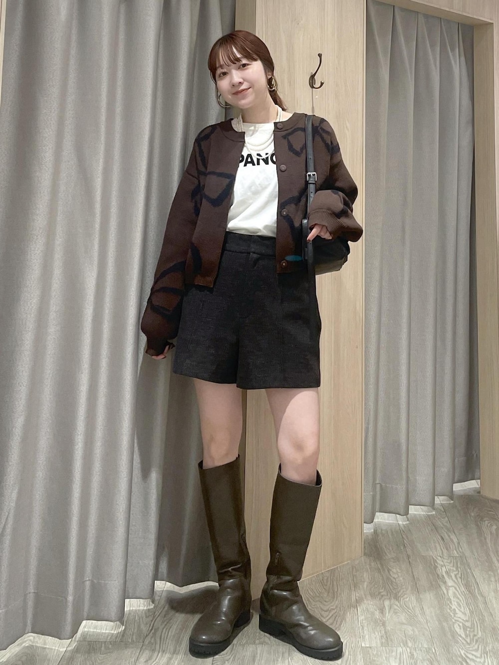 ホワイト系のTシャツ/カットソー、ブラック系のショルダーバッグ、ブラウン系のカーディガン/ボレロを着用したレディースの秋コーディネートの1枚目の写真