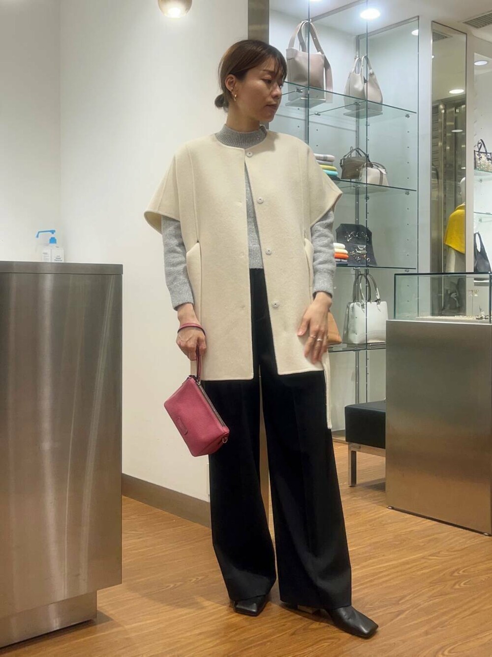 ホワイト系のポンチョ、ブラック系のその他パンツ、グレー系のニット/セーターを着用したレディースの秋コーディネートの1枚目の写真