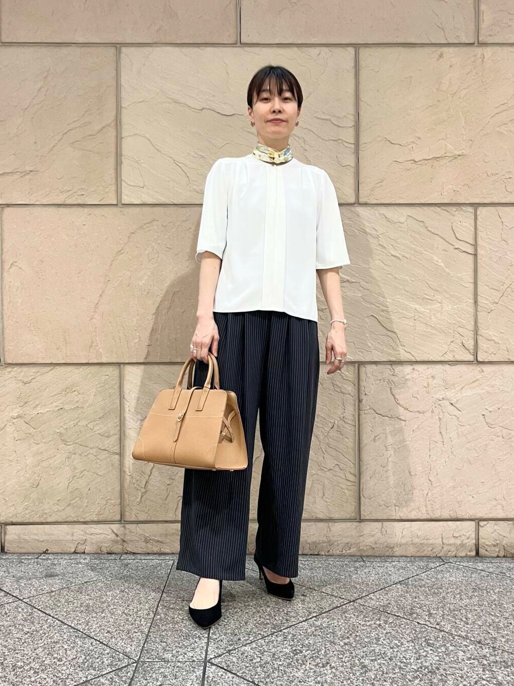 ブラック系のパンプス、ホワイト系のシャツ/ブラウス、イエロー系のトートバッグを着用したレディースの夏コーディネートの1枚目の写真