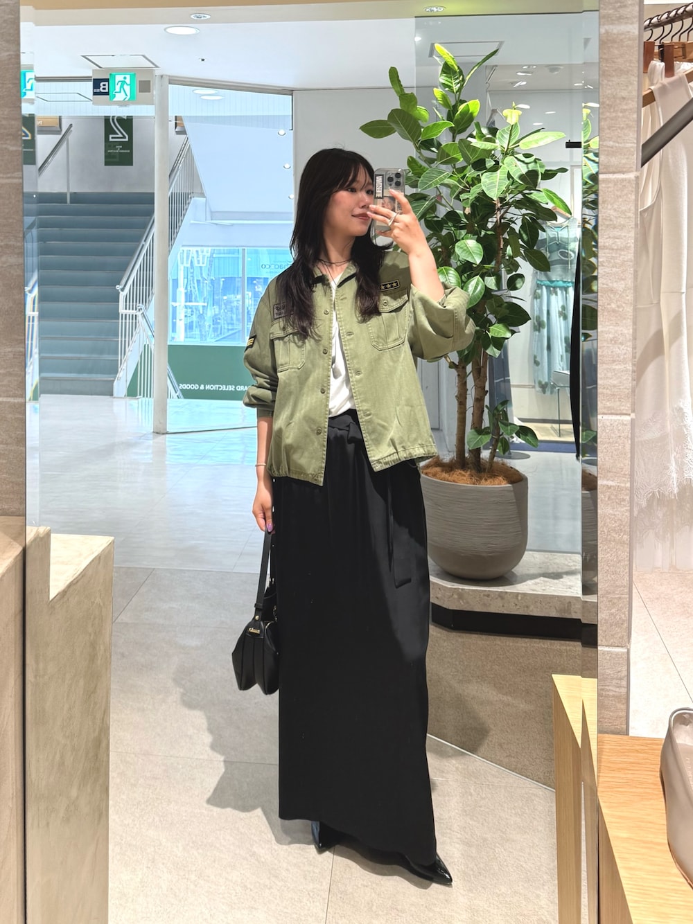 グリーン系のシャツ/ブラウス、ブラック系のスカートを着用したレディースの夏コーディネートの1枚目の写真