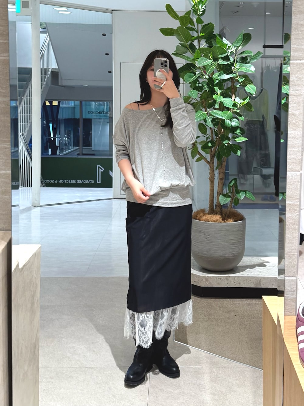 グレー系のTシャツ/カットソー、ブラック系のスカートを着用したレディースの秋コーディネートの1枚目の写真
