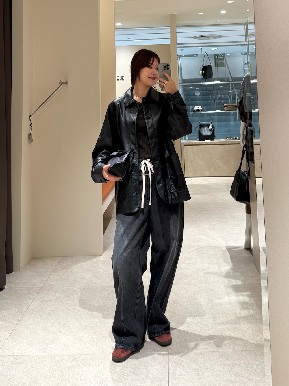 ブラック系のデニムパンツ、ブラック系のその他アウターを着用したレディースの秋コーディネートの1枚目の写真
