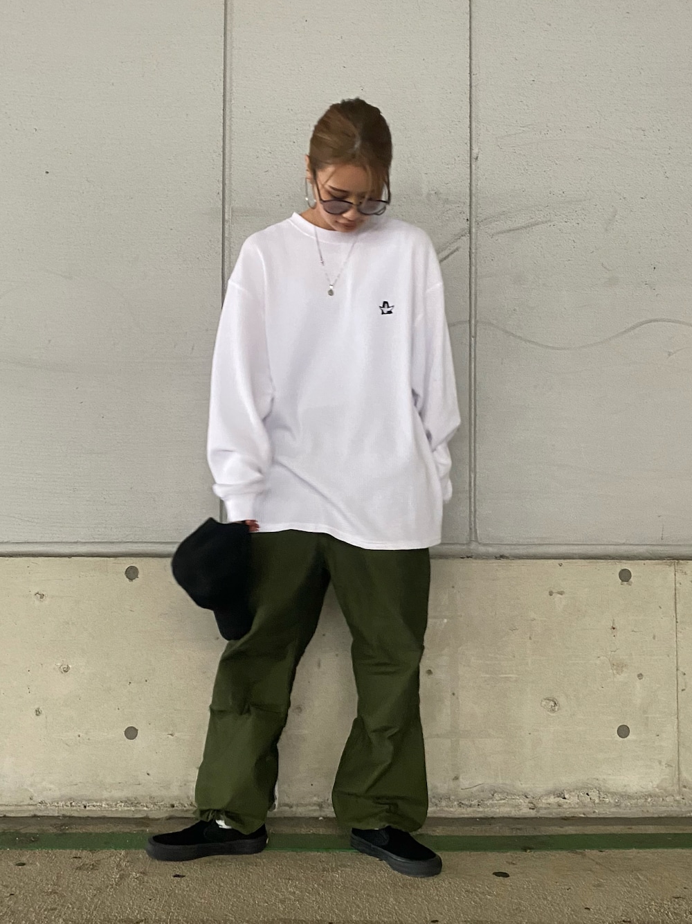 ホワイト系のトップス、グリーン系のカーゴパンツを着用したレディースの夏コーディネートの1枚目の写真