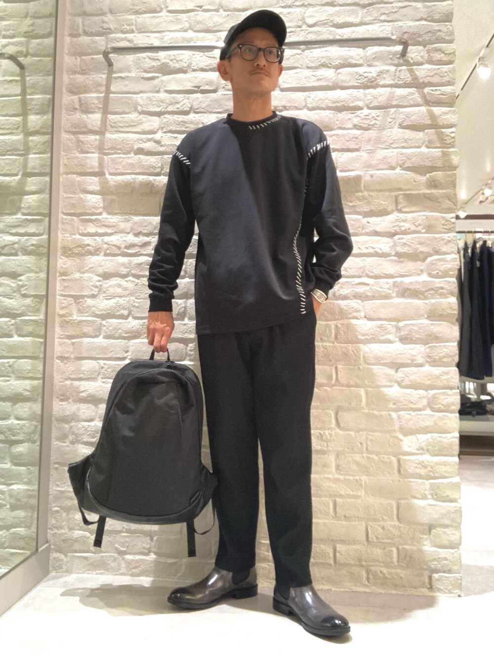 ブラック系のバックパック/リュック、グレー系のブーツを着用したメンズの秋コーディネートの1枚目の写真