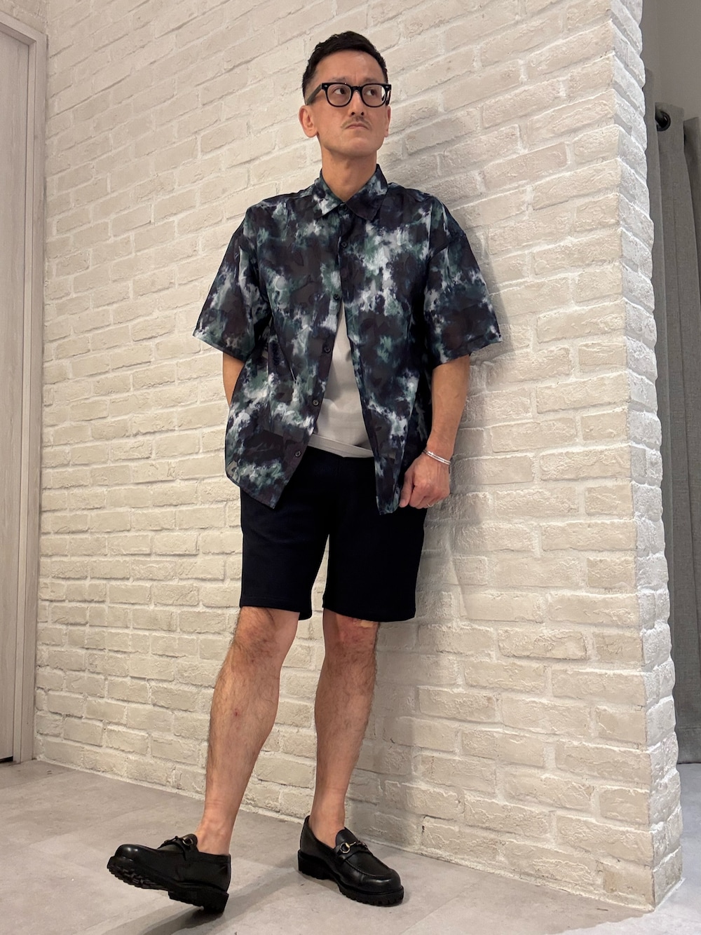 ブラック系のローファーを着用したメンズの夏コーディネートの1枚目の写真