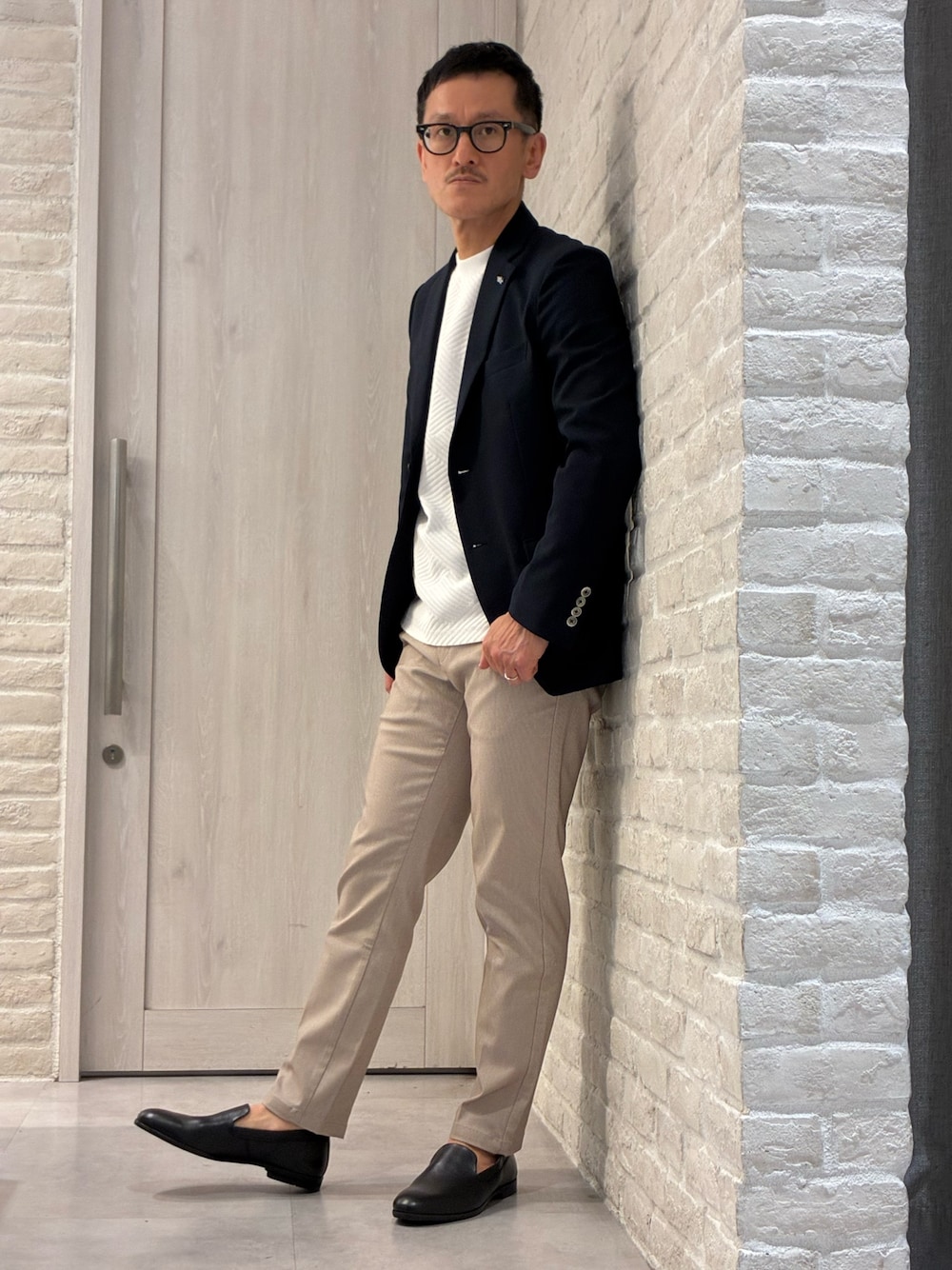 ブラック系のスリッポンを着用したメンズの春コーディネートの1枚目の写真