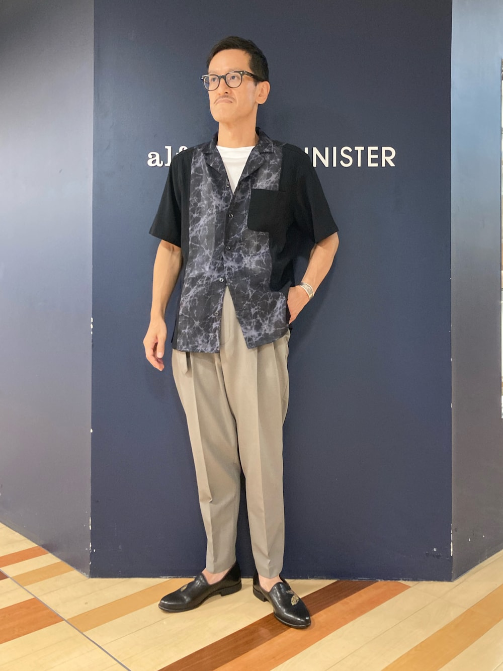 ブラック系のシャツ/ブラウス、ベージュ系のその他パンツ、その他のローファーを着用したメンズの夏コーディネートの1枚目の写真