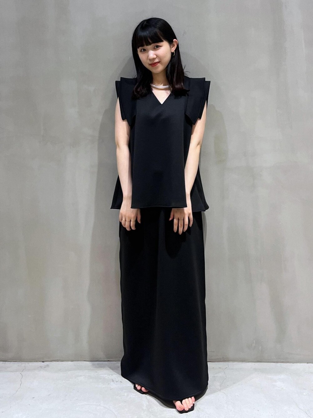 ブラック系のサンダル、ブラック系のスカート、ブラック系のTシャツ/カットソーを着用したレディースの夏コーディネートの1枚目の写真