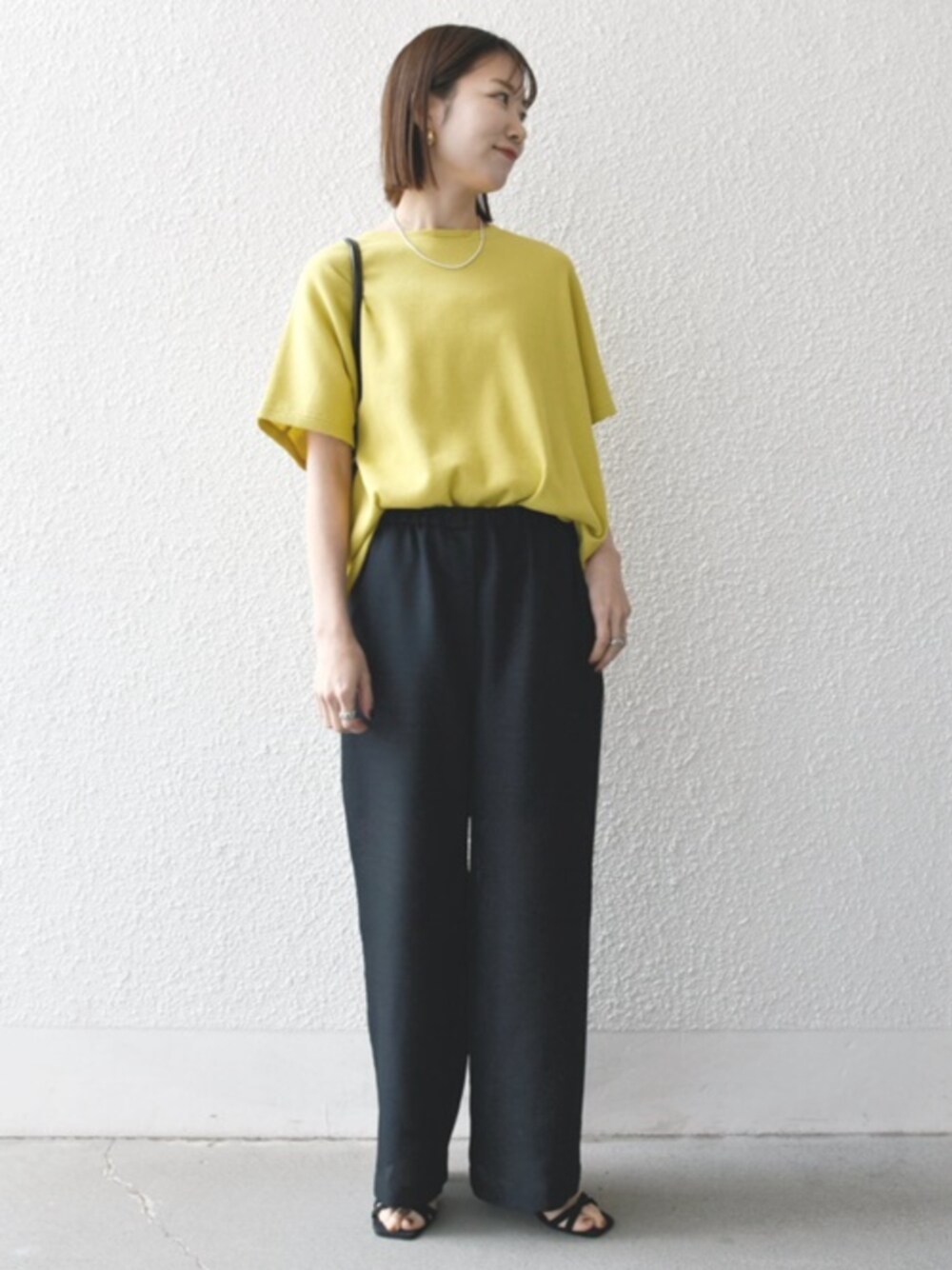 ブラック系のサンダル、イエロー系のTシャツ/カットソーを着用したレディースの春コーディネートの1枚目の写真