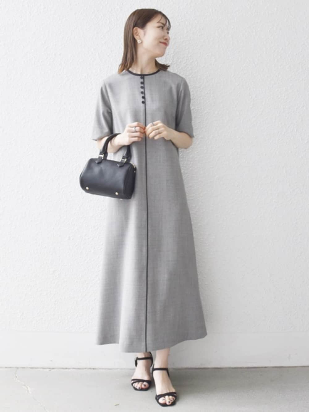 ブラック系のサンダル、ブラック系のボストンバッグ、グレー系のワンピースを着用したレディースの夏コーディネートの1枚目の写真