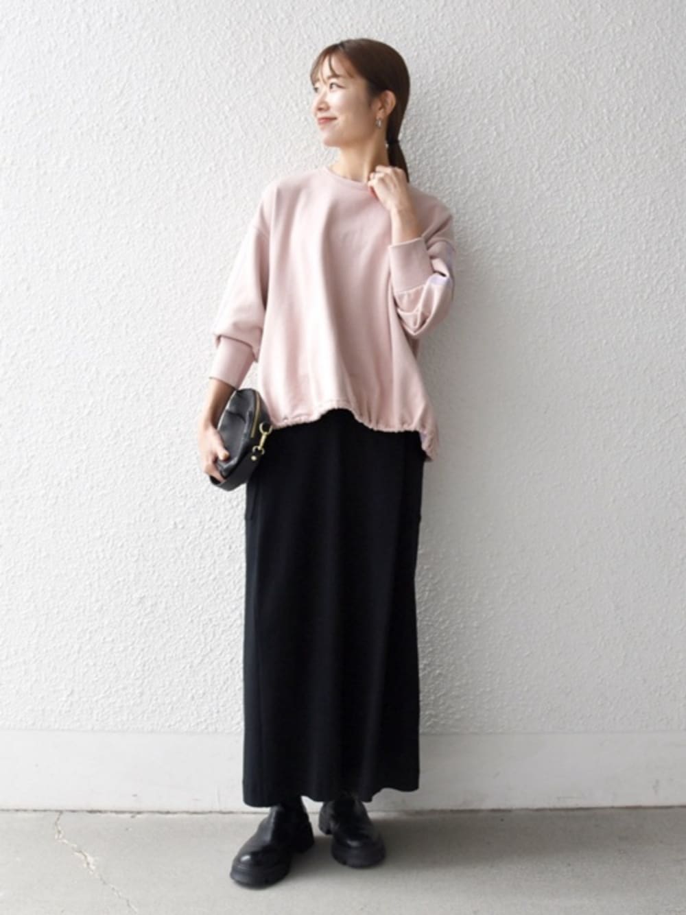 ブラック系のブーツ、ピンク系のスウェットを着用したレディースの秋コーディネートの1枚目の写真