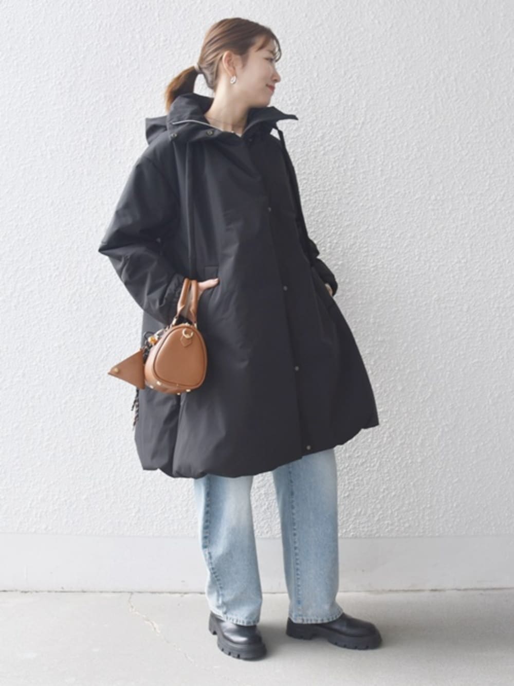 ブルー系のデニムパンツ、ブラック系のブーツ、ブラック系のその他アウターを着用したレディースの秋コーディネートの1枚目の写真