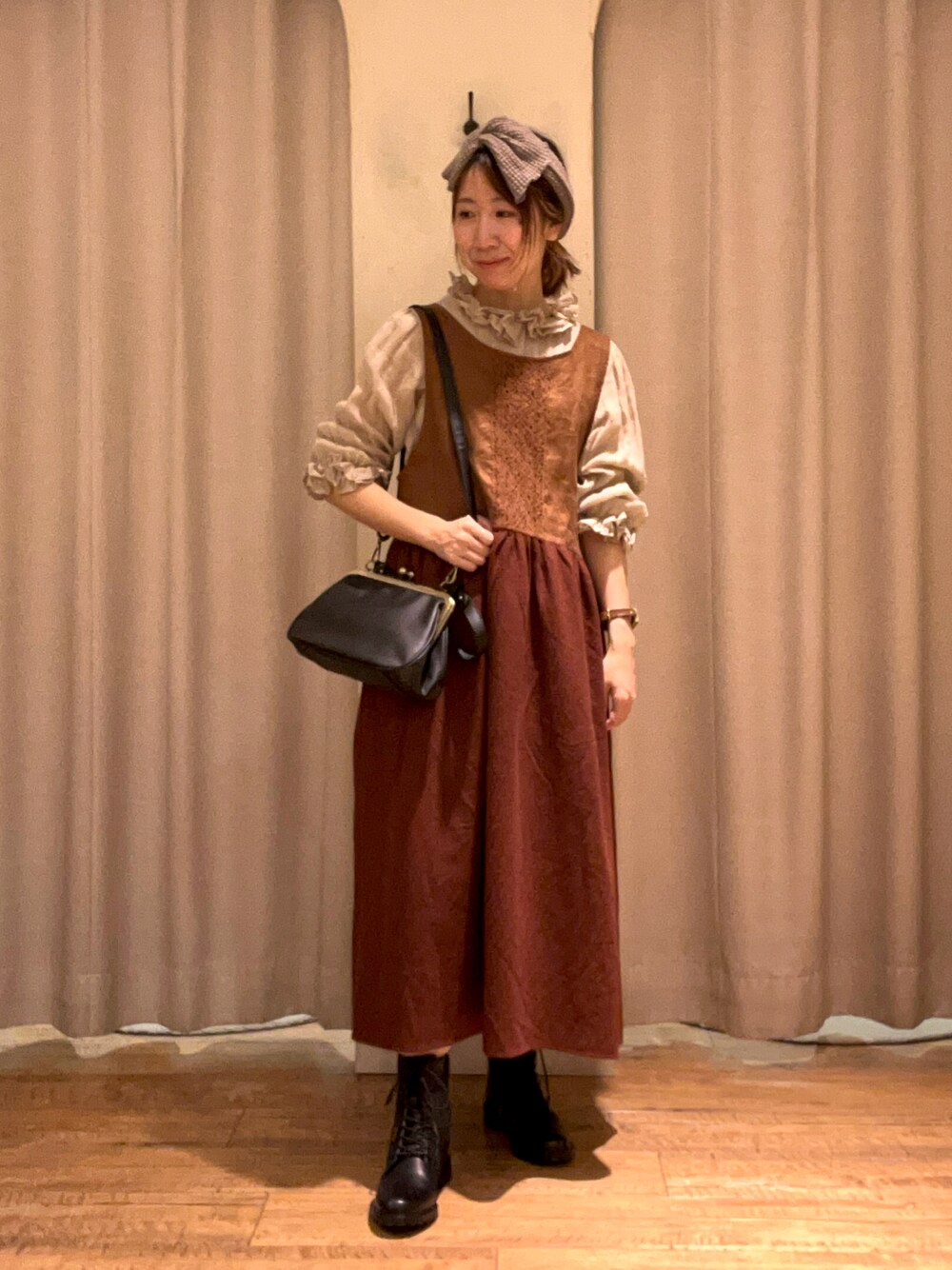 ブラウン系のワンピース、グリーン系のシャツ/ブラウス、ブラック系のハンドバッグを着用したレディースの秋コーディネートの1枚目の写真