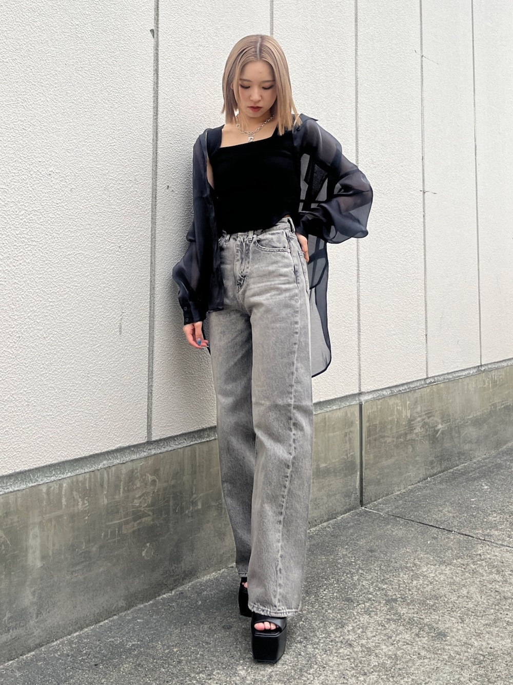 グレー系のデニムパンツ、ブラック系のサンダル、ブラック系のタンクトップを着用したレディースの春コーディネートの1枚目の写真