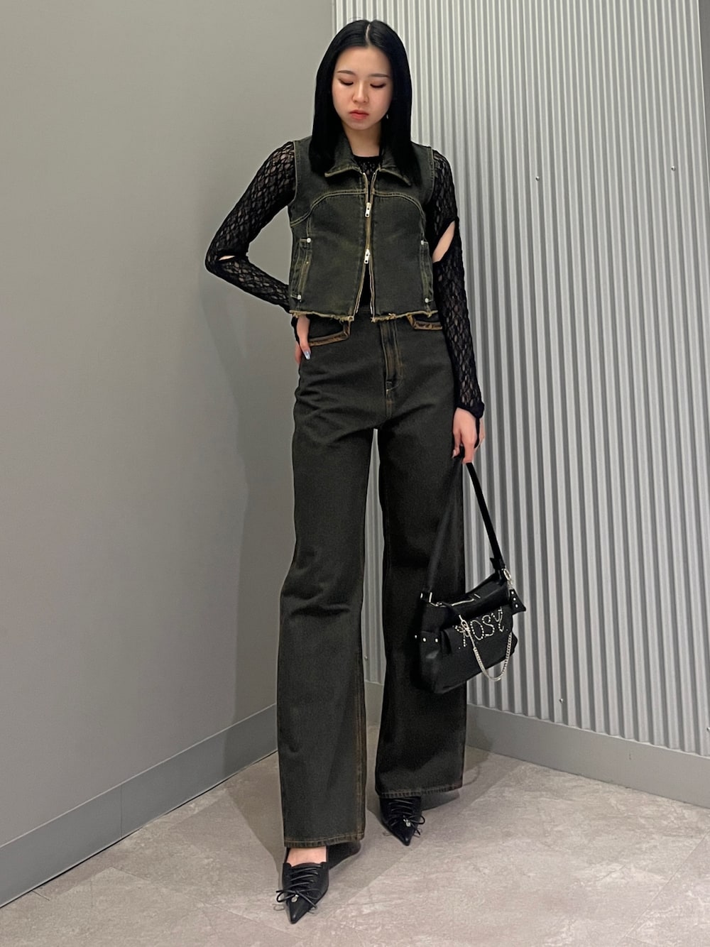 ブルー系のデニムパンツ、ブルー系のベスト、ブラック系のTシャツ/カットソーを着用したレディースの春コーディネートの1枚目の写真