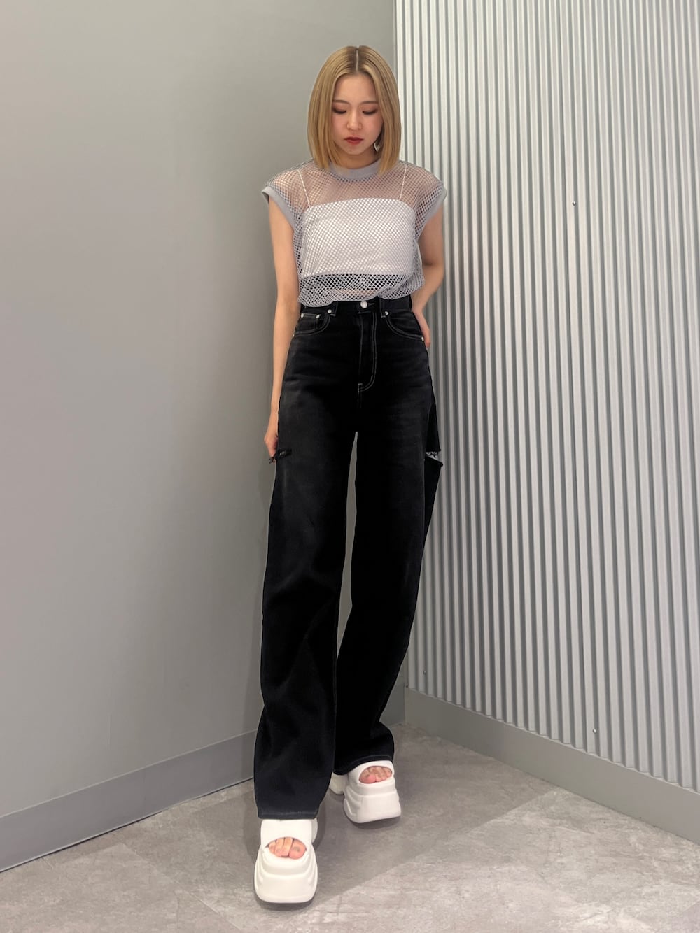 ブラック系のデニムパンツ、グレー系のTシャツ/カットソー、ホワイト系のサンダルを着用したレディースの夏コーディネートの1枚目の写真