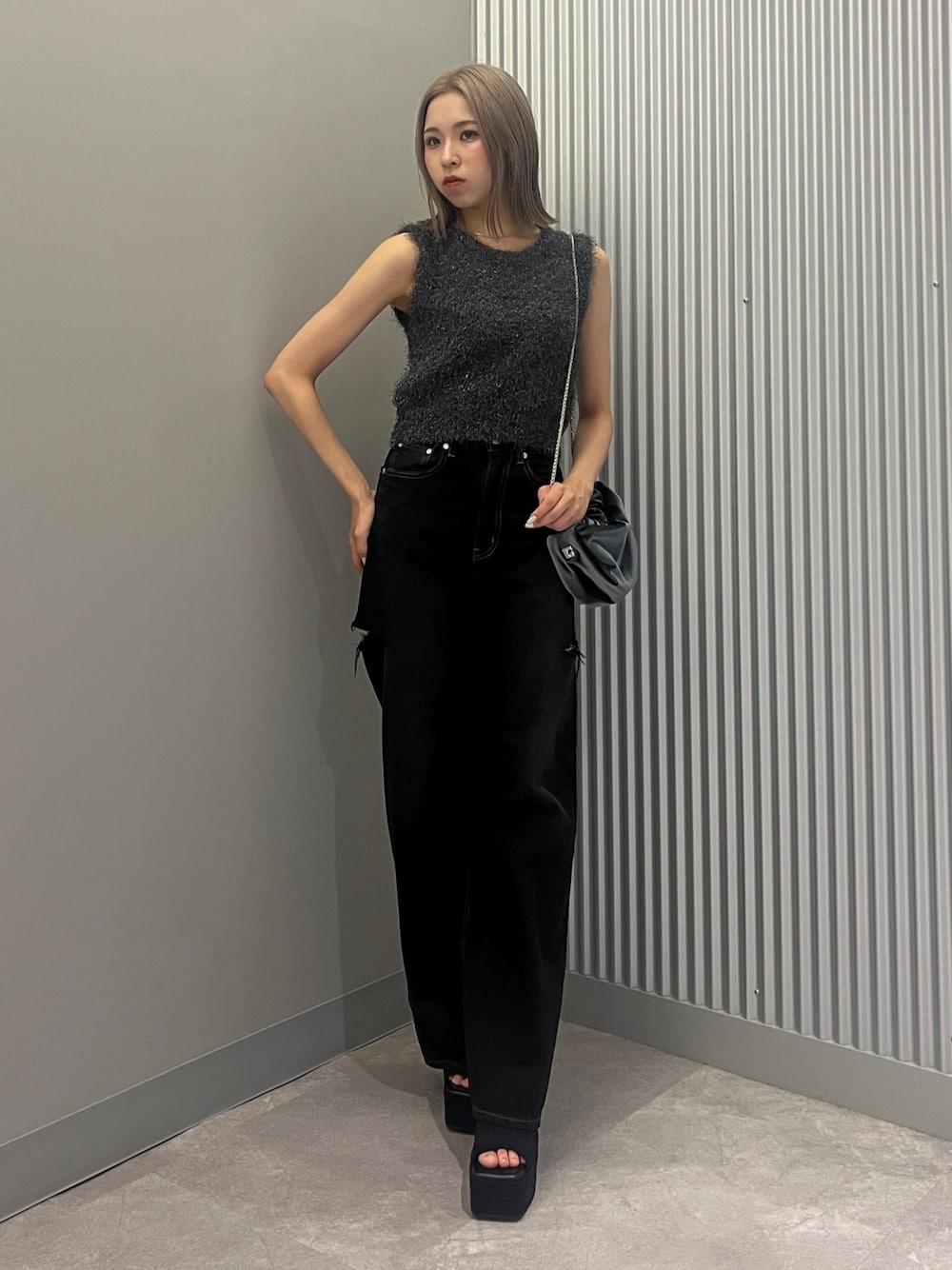 ブラック系のデニムパンツ、グレー系のハンドバッグ、ブラック系のサンダルを着用したレディースの夏コーディネートの1枚目の写真