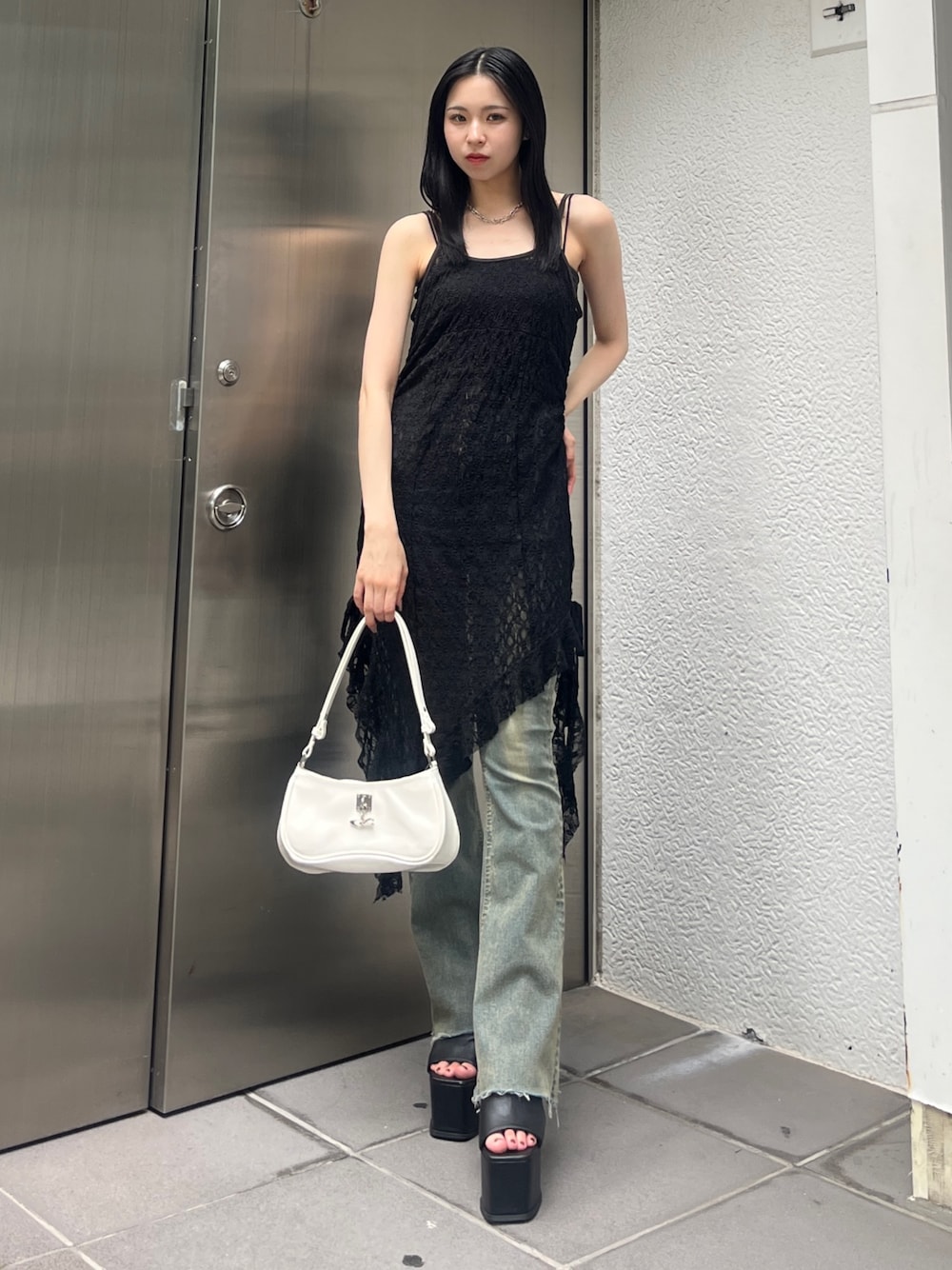 ブルー系のデニムパンツ、ホワイト系のショルダーバッグ、ブラック系のサンダルを着用したレディースの夏コーディネートの1枚目の写真