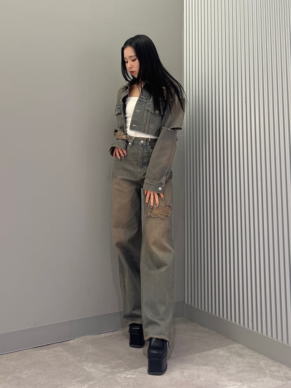 グレー系のデニムパンツ、ブラック系のサンダル、グレー系のデニムジャケットを着用したレディースの冬コーディネートの1枚目の写真