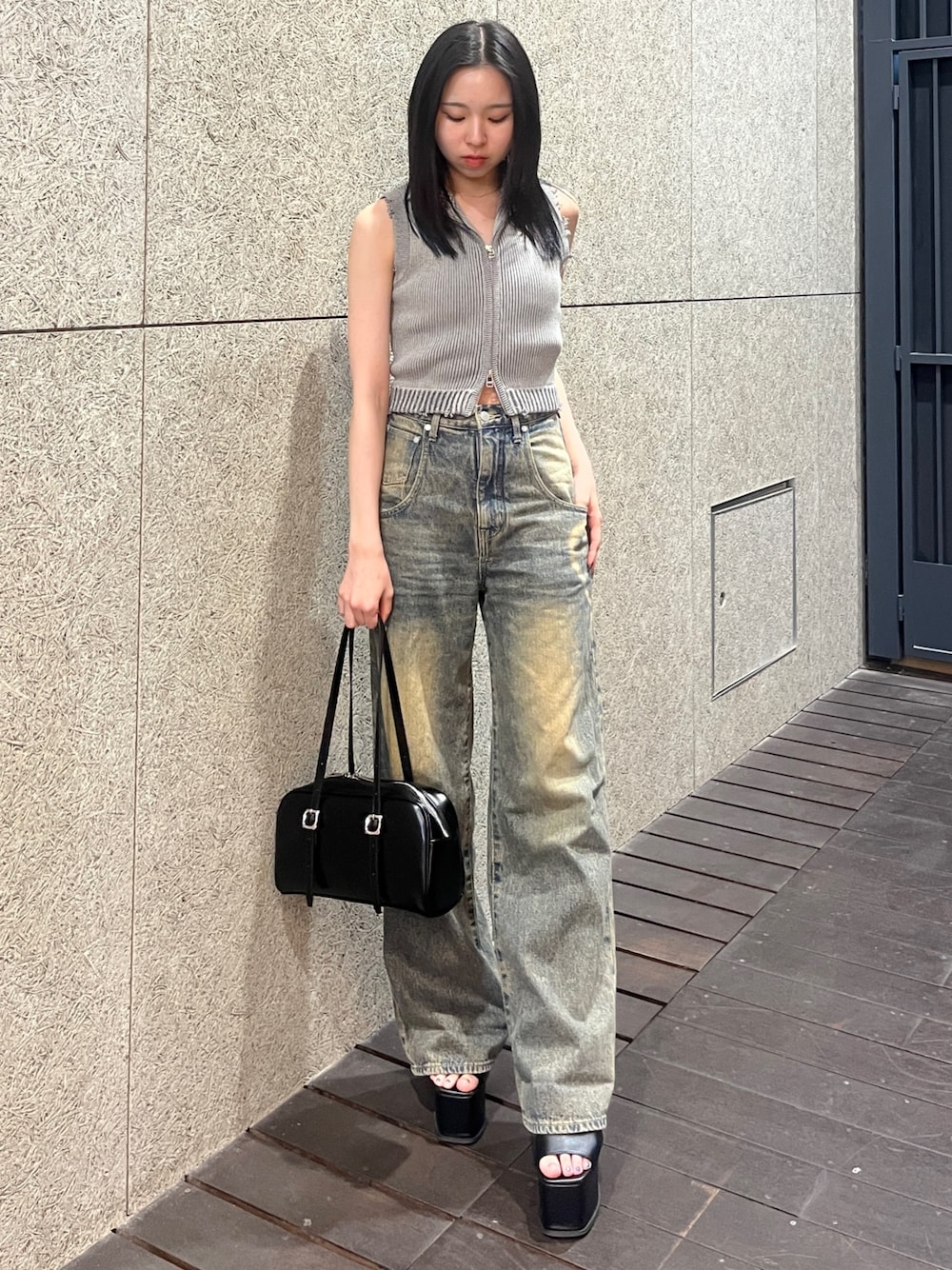 グレー系のタンクトップ、ブルー系のデニムパンツ、ブラック系のハンドバッグを着用したレディースの春コーディネートの1枚目の写真