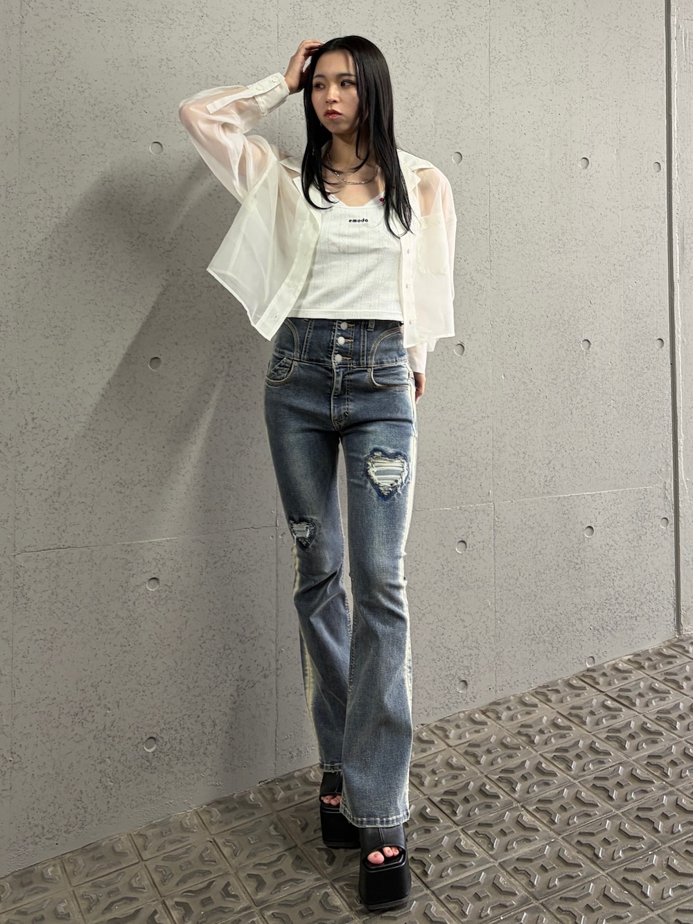 ブルー系のデニムパンツ、ブラック系のサンダル、ホワイト系のキャミソールを着用したレディースの春コーディネートの1枚目の写真