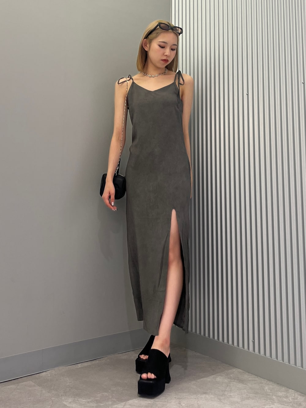 ブラック系のハンドバッグ、ブラック系のワンピース、ブラック系のサンダルを着用したレディースの夏コーディネートの1枚目の写真