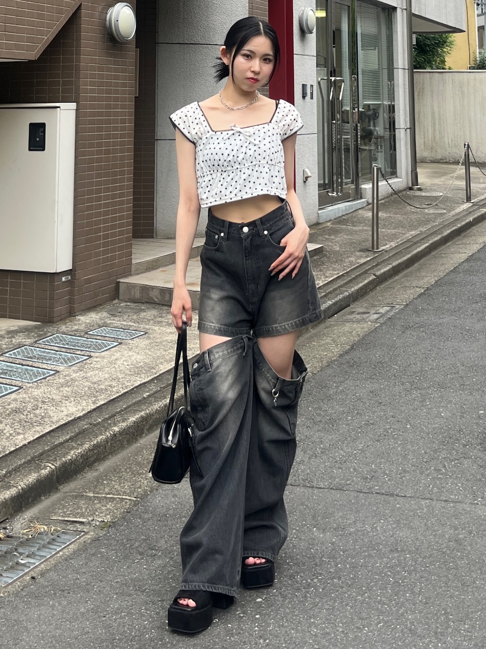 ホワイト系のタンクトップ、ブラック系のデニムパンツ、ブラック系のハンドバッグを着用したレディースの夏コーディネートの1枚目の写真