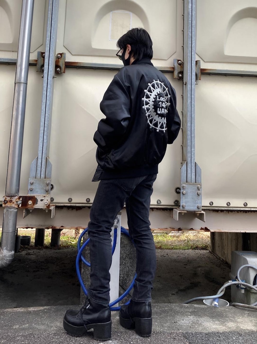 ブラック系のスカジャン、ブラック系のパンツ、ブラック系のブーツを着用したメンズの冬コーディネートの1枚目の写真