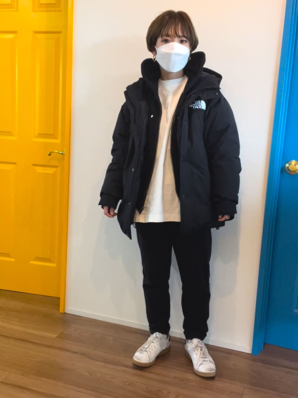 ブラック系のダウンジャケット/コート、ブラック系のパーカー、ホワイト系のTシャツ/カットソーを着用したレディースの冬コーディネートの1枚目の写真