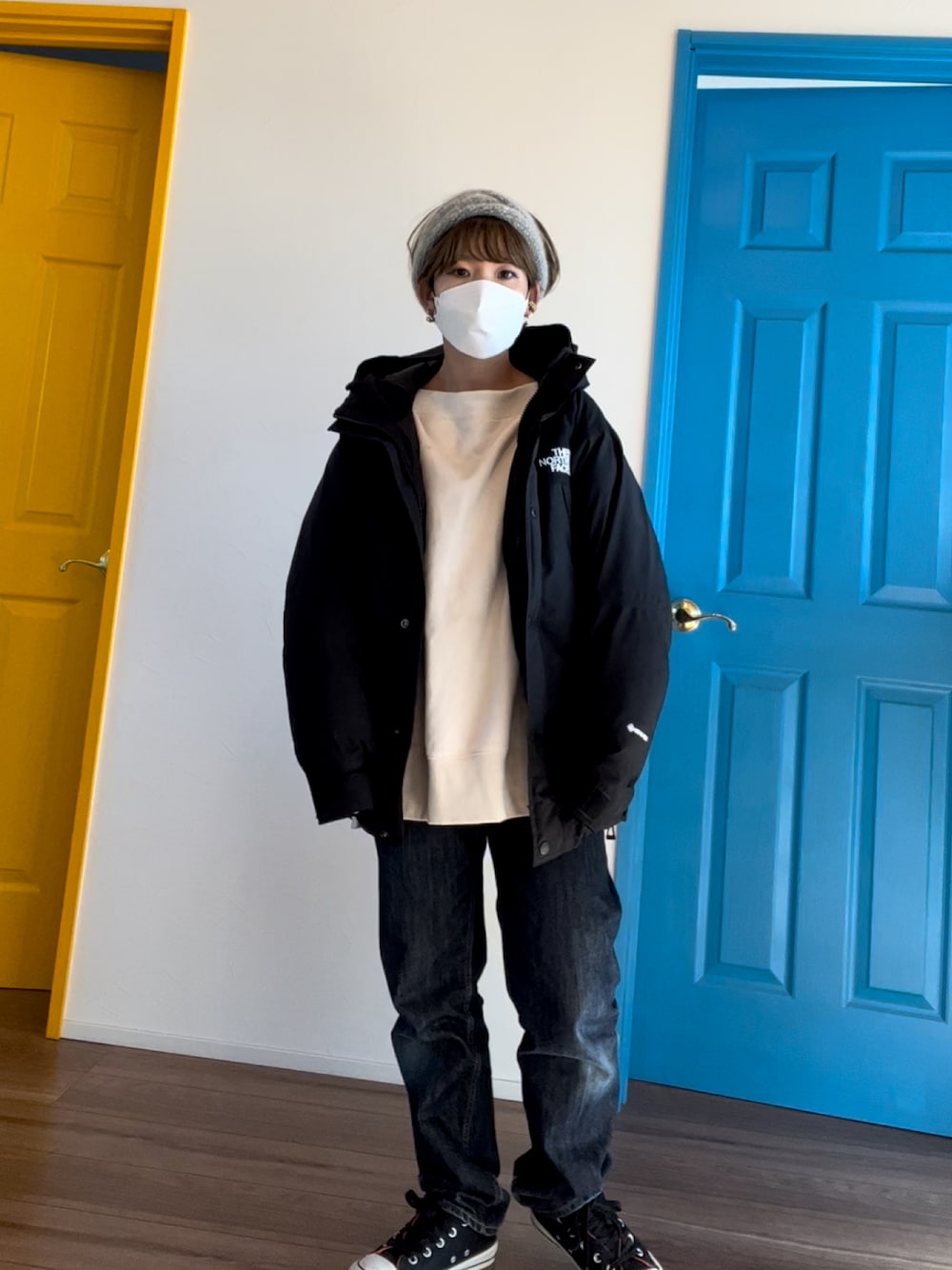 ブラック系のダウンジャケット/コート、ホワイト系のスウェット、ブルー系のデニムパンツを着用したレディースの冬コーディネートの1枚目の写真