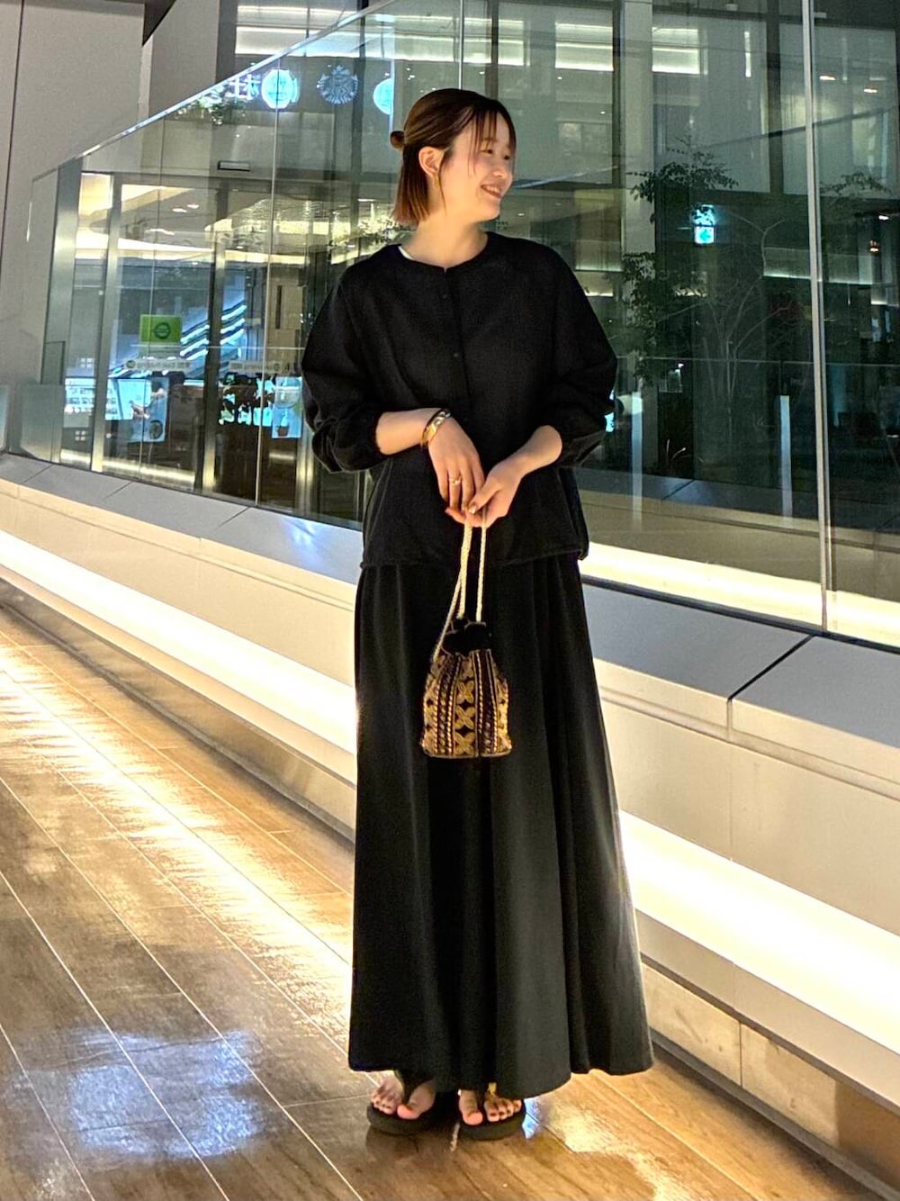 ブラック系のショルダーバッグ、ブラック系のスカート、ブラック系のカーディガン/ボレロを着用したレディースの夏コーディネートの1枚目の写真