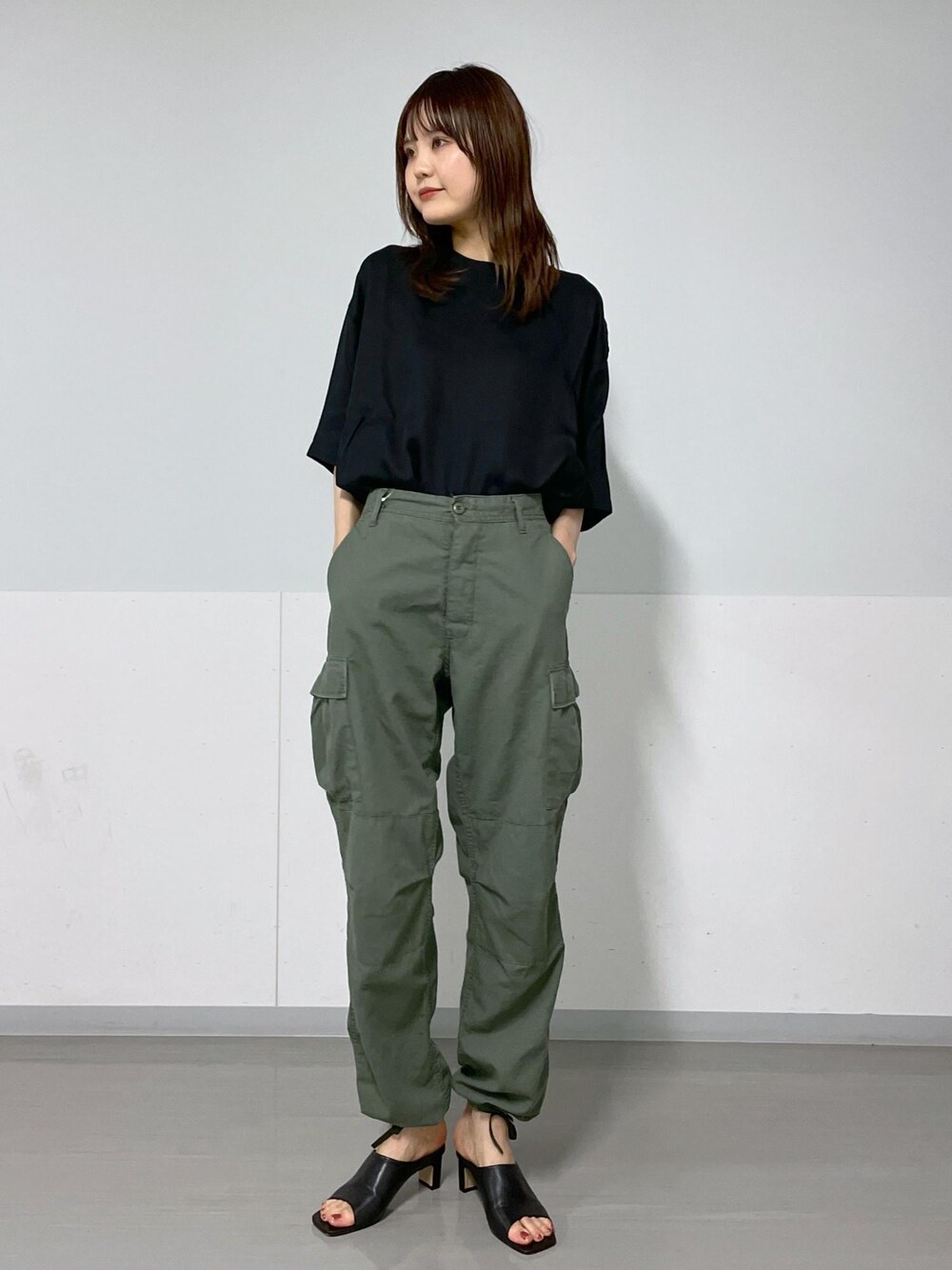 ホワイト系のトートバッグ、ブラック系のサンダル、グリーン系のカーゴパンツを着用したレディースの夏コーディネートの1枚目の写真