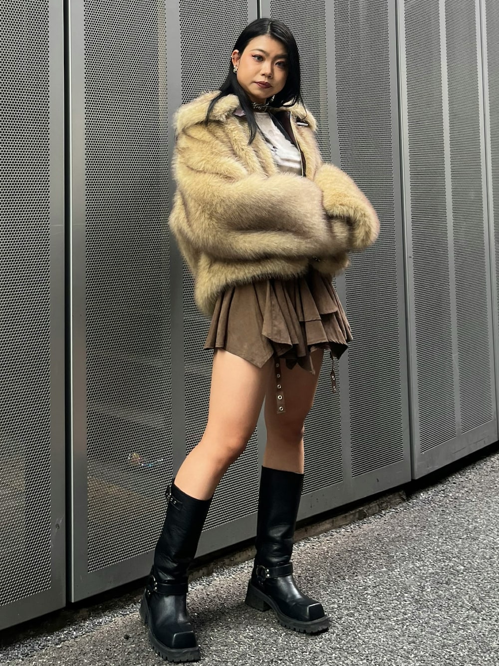 ブラウン系のスカート、ブラック系のブーツ、ベージュ系のその他アウターを着用したレディースの冬コーディネートの1枚目の写真