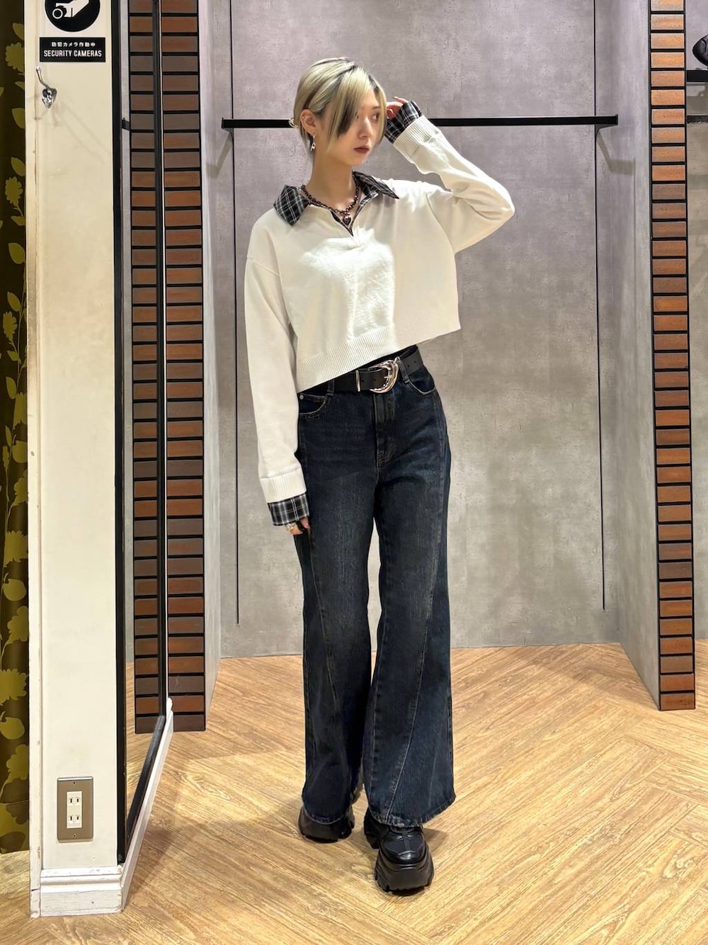 ブラック系のスニーカー、ブルー系のデニムパンツ、ホワイト系のニット/セーターを着用したレディースの秋コーディネートの1枚目の写真