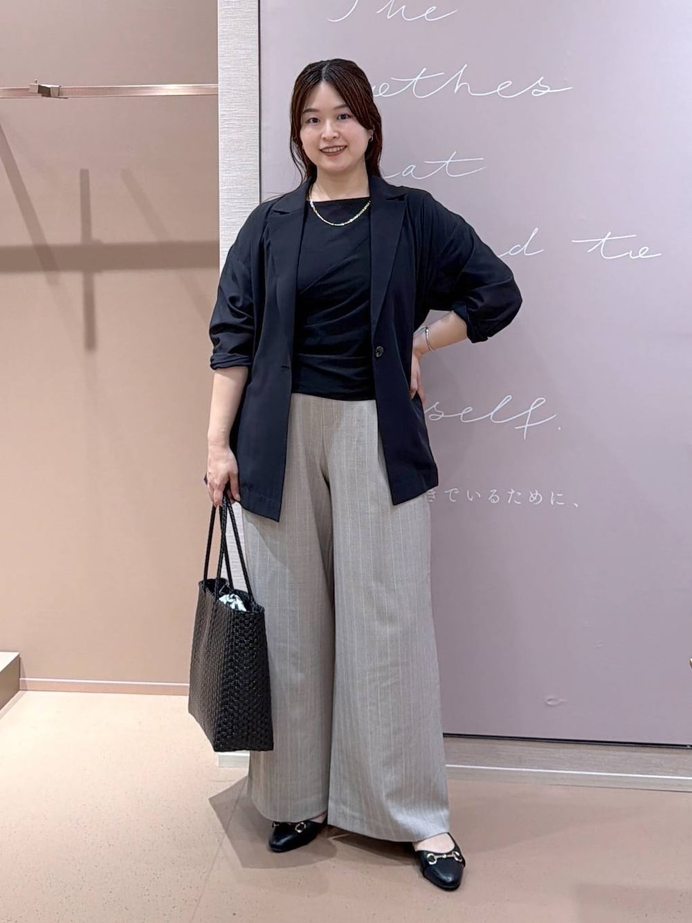 ブラック系のパンプス、ブラック系のテーラードジャケット、ブラック系のかごバッグを着用したレディースの夏コーディネートの1枚目の写真