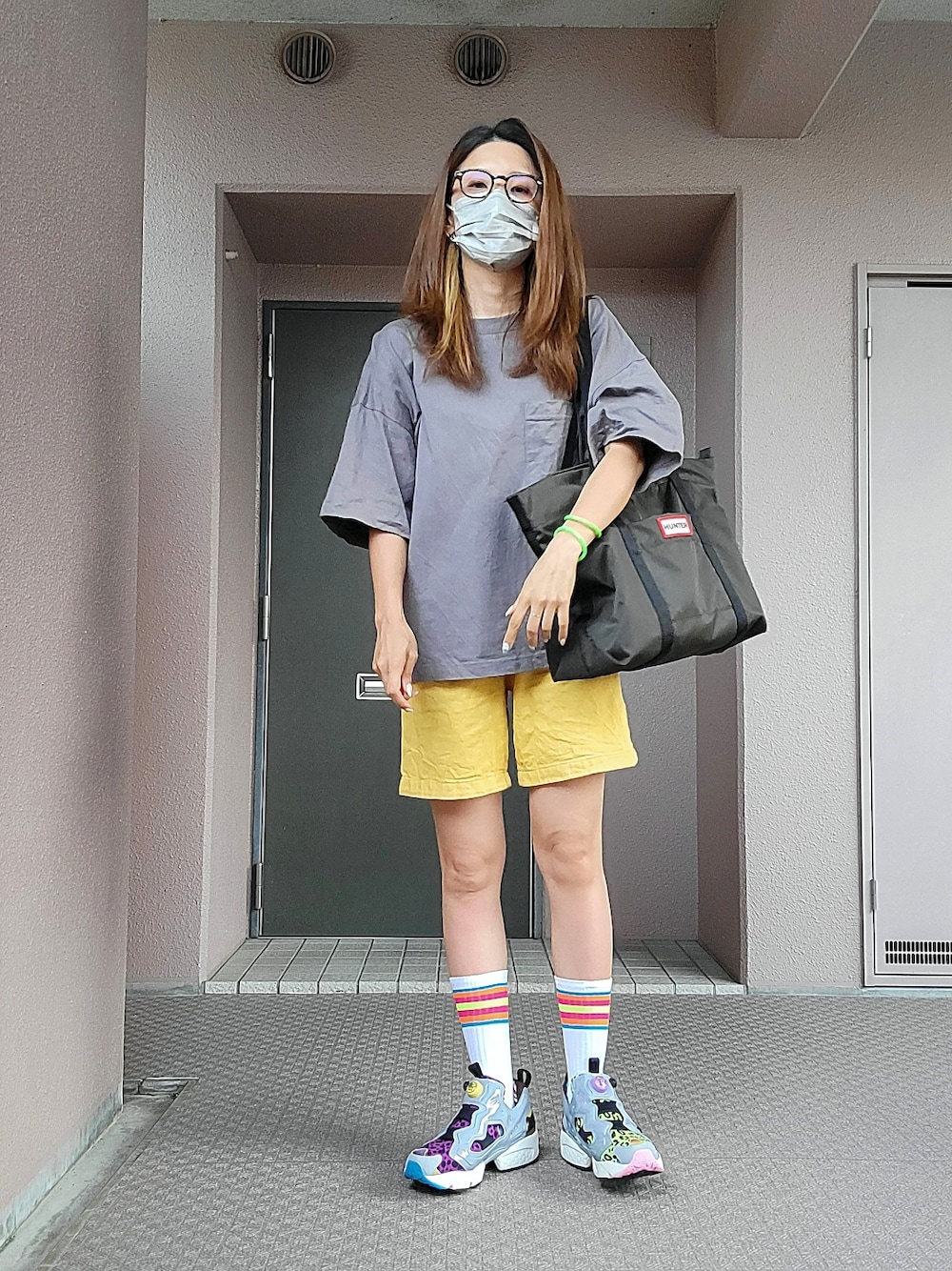 グレー系のTシャツ/カットソー、グリーン系のトートバッグ、イエロー系のパンツを着用したレディースの夏コーディネートの1枚目の写真