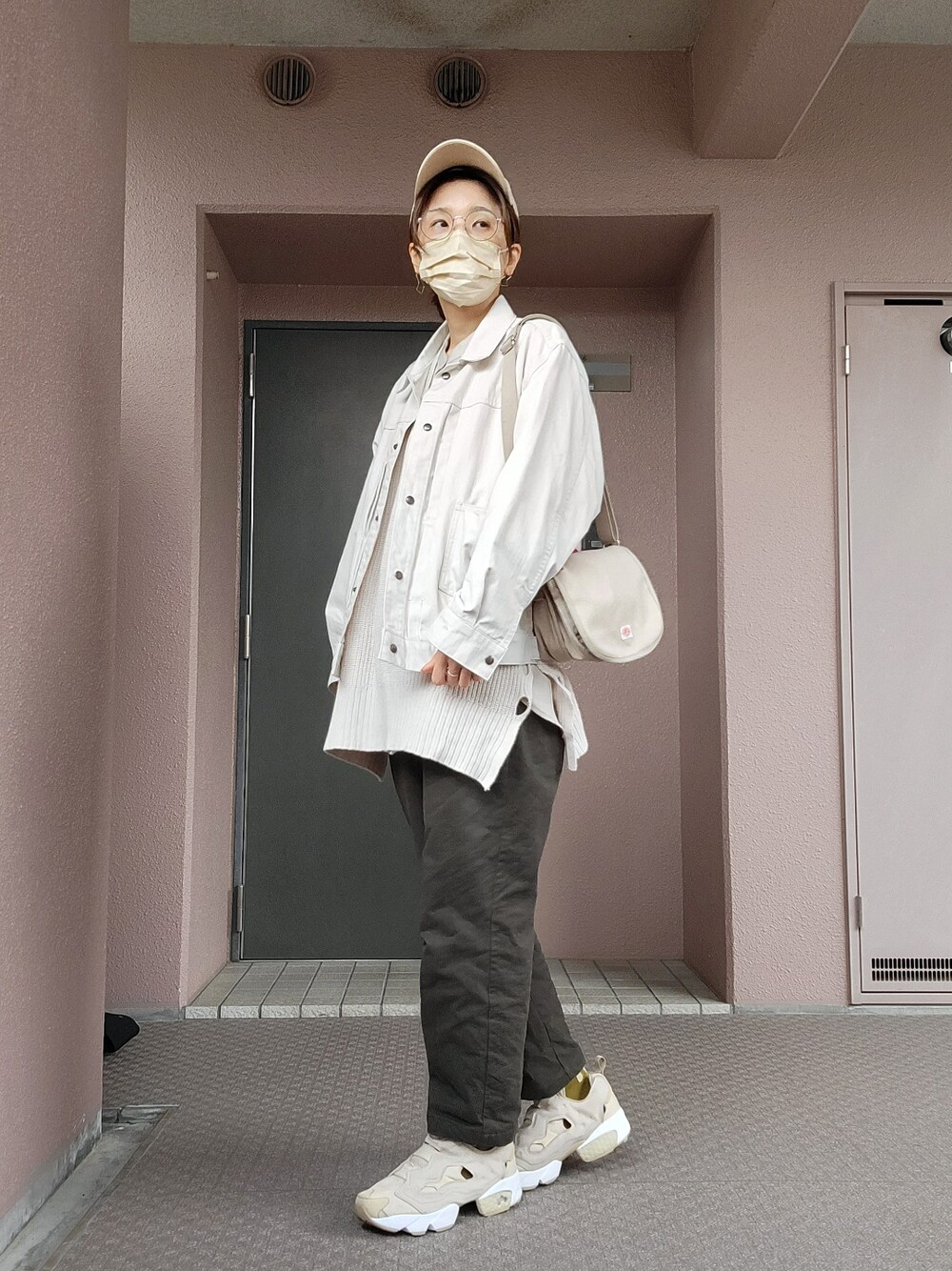 ベージュ系のショルダーバッグ、ホワイト系のデニムジャケット、ベージュ系のシャツ/ブラウスを着用したレディースの春コーディネートの2枚目の写真