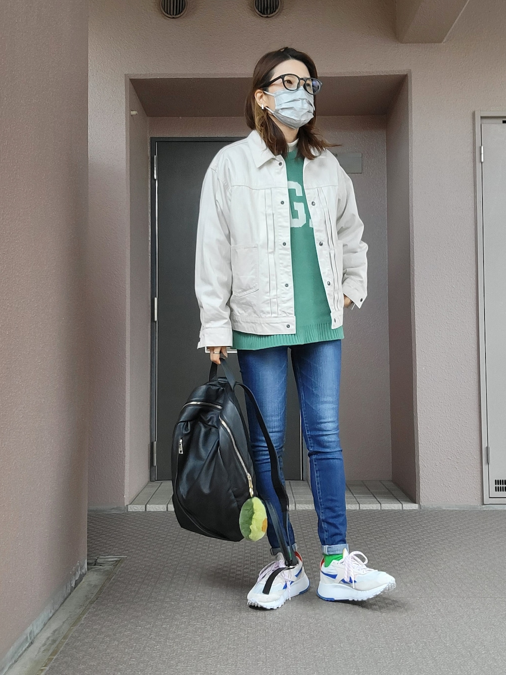 ブルー系のデニムパンツ、グレー系のスニーカー、ブラック系のバックパック/リュックを着用したレディースの冬コーディネートの2枚目の写真