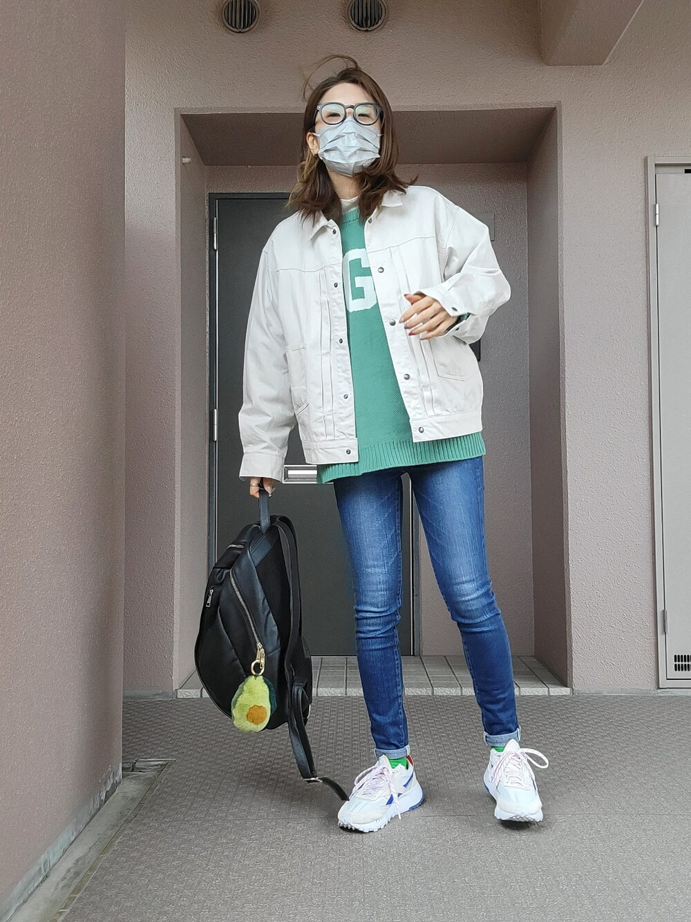 ブルー系のデニムパンツ、グレー系のスニーカー、ブラック系のバックパック/リュックを着用したレディースの冬コーディネートの1枚目の写真