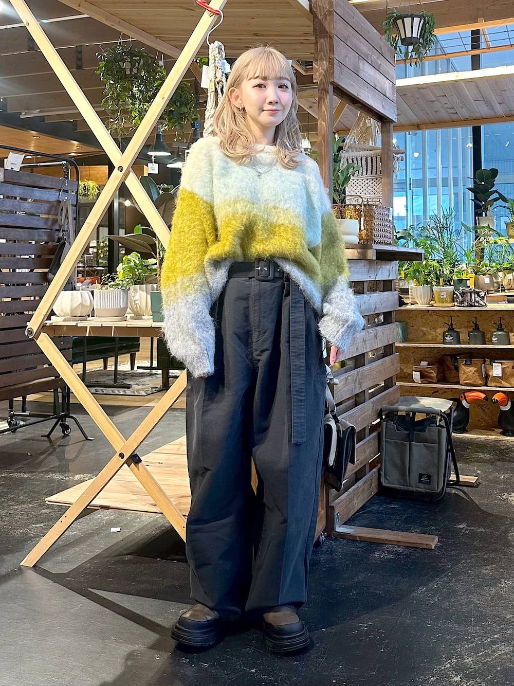 グレー系のその他パンツ、ブラウン系のブーツ、イエロー系のニット/セーターを着用したレディースの冬コーディネートの1枚目の写真