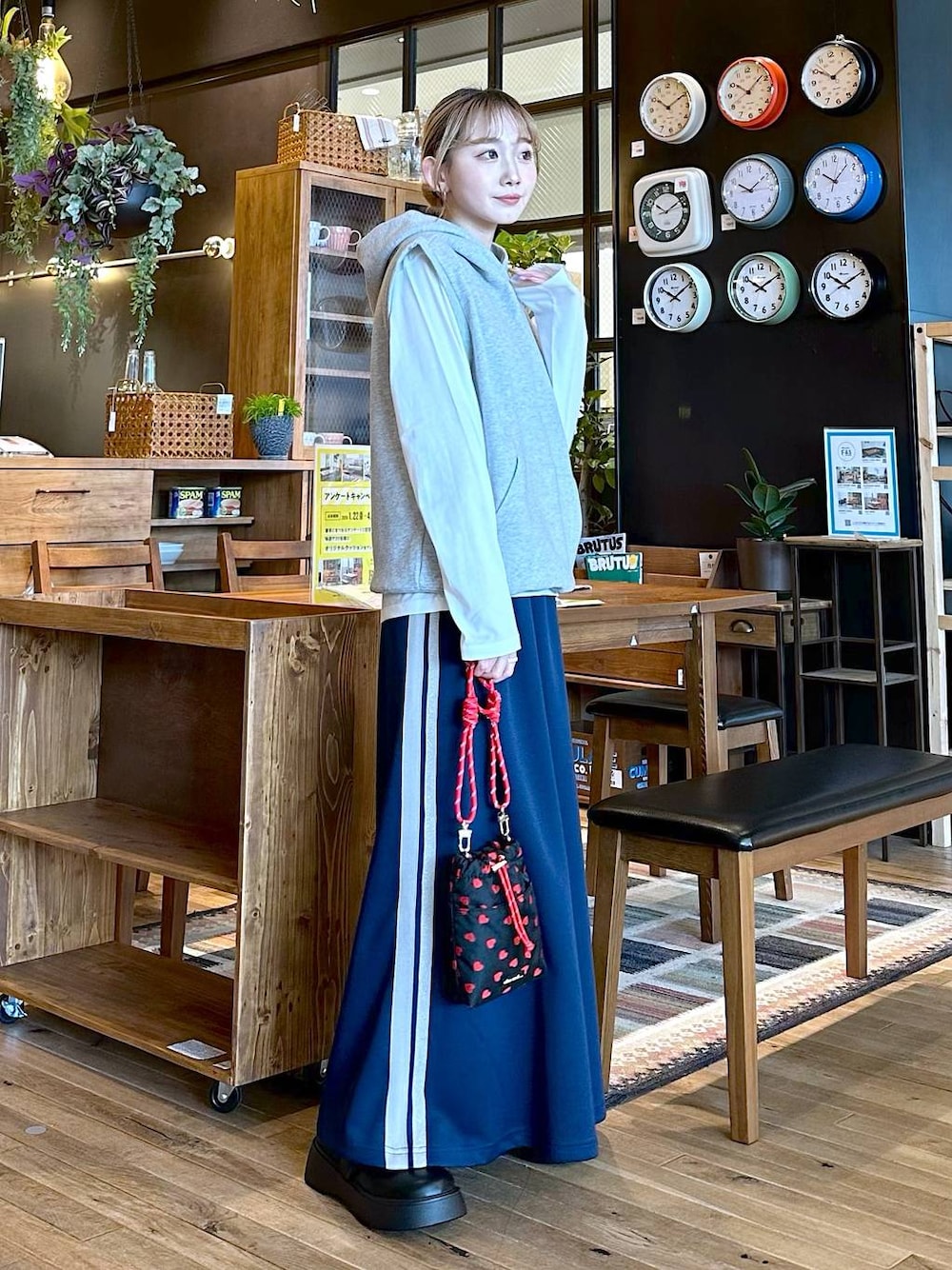 ブラック系のショルダーバッグ、ホワイト系のTシャツ/カットソー、ブルー系のスカートを着用したレディースの冬コーディネートの1枚目の写真